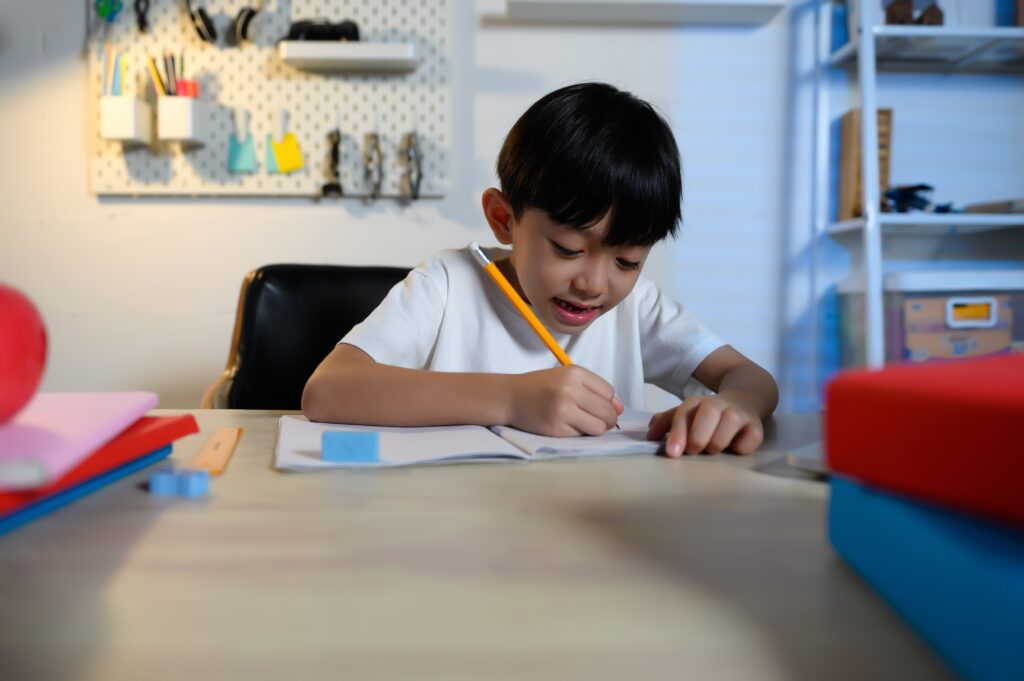 Asian,Kid,Boy,Happiness,Focused,On,Homework,And,Learning,Alone